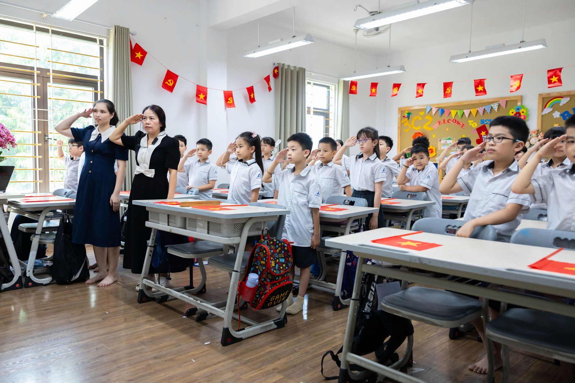 Children and teachers saluting in a colorful classroom decorated with flags. — Cultivating Critical Thinkers: The Role of Oxf