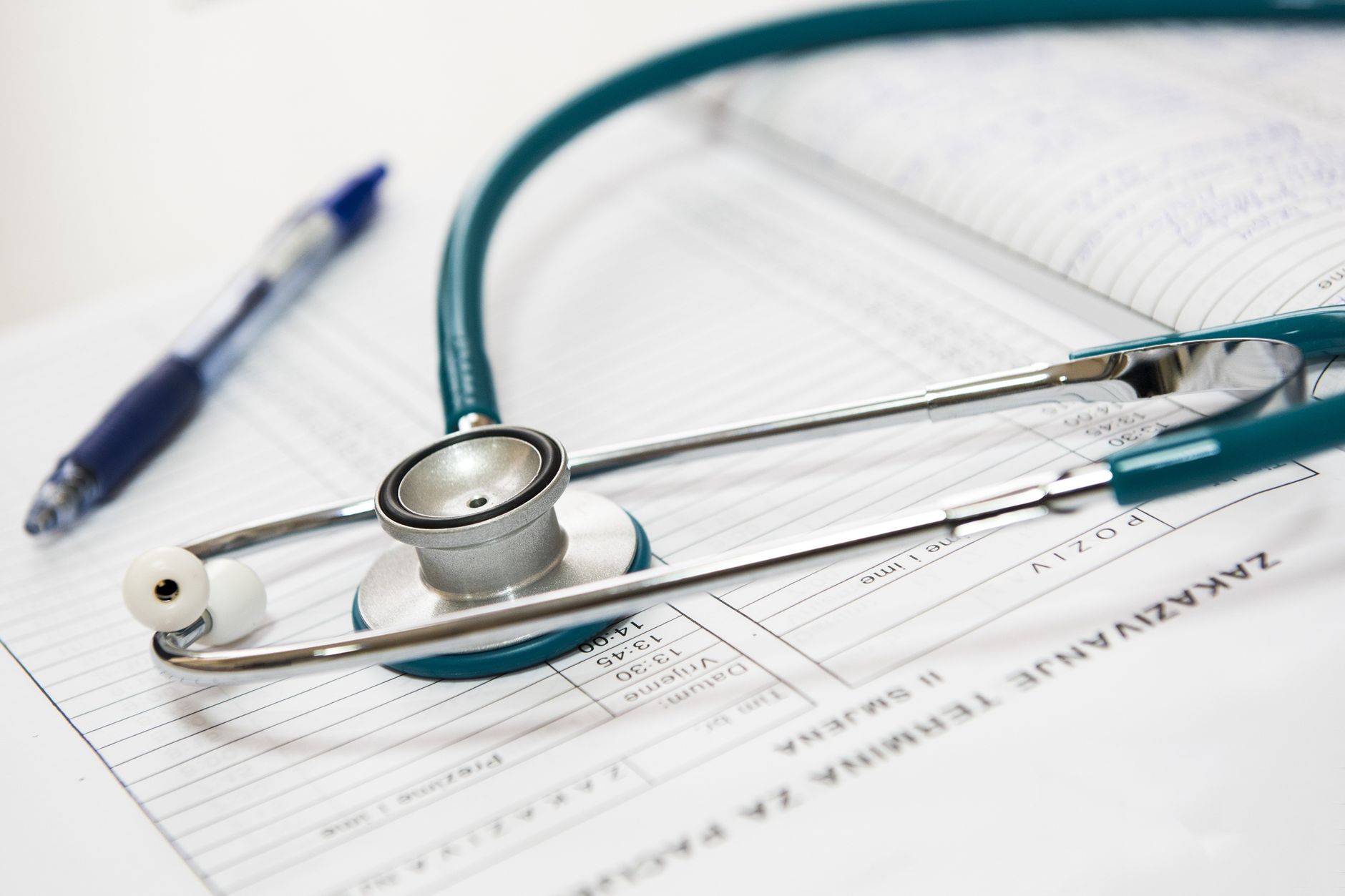 A stethoscope and pen resting on a medical report in a healthcare setting. — Expert Tips on Picking a Medicare Advantage Plan