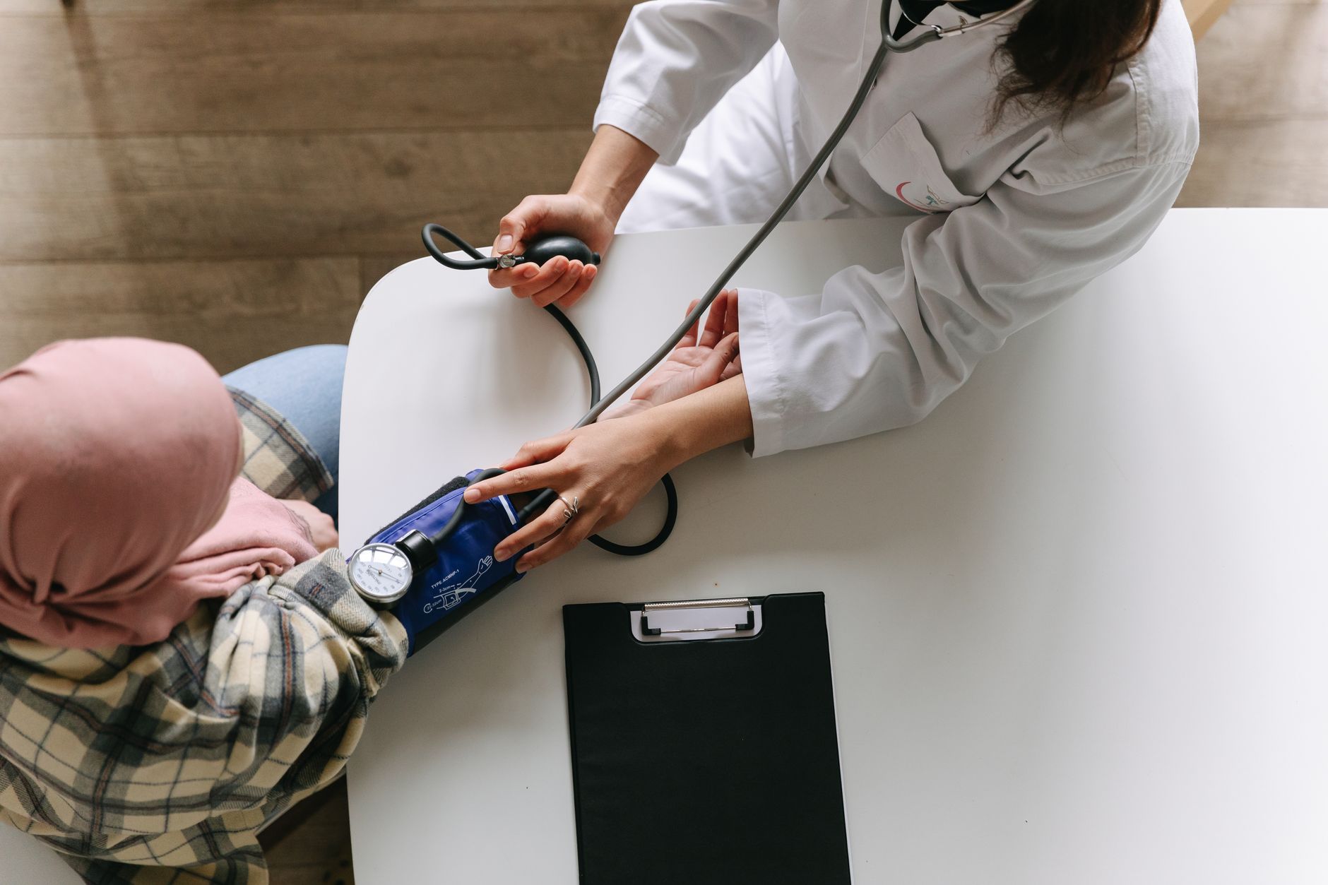 A medical practitioner checks a patient's blood pressure in a clinical setting, showcasing healthcare service. — How Mail Ord